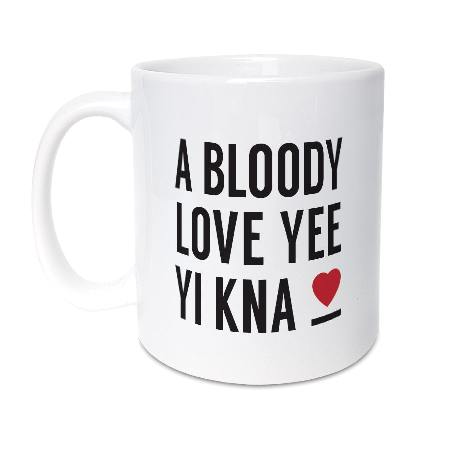 White ceramic coffee mug featuring the text 'A BLOODY LOVE YEE YI KNA' in black with a small red heart. Funny Geordie Valentine's gift designed by Geordie Gifts.