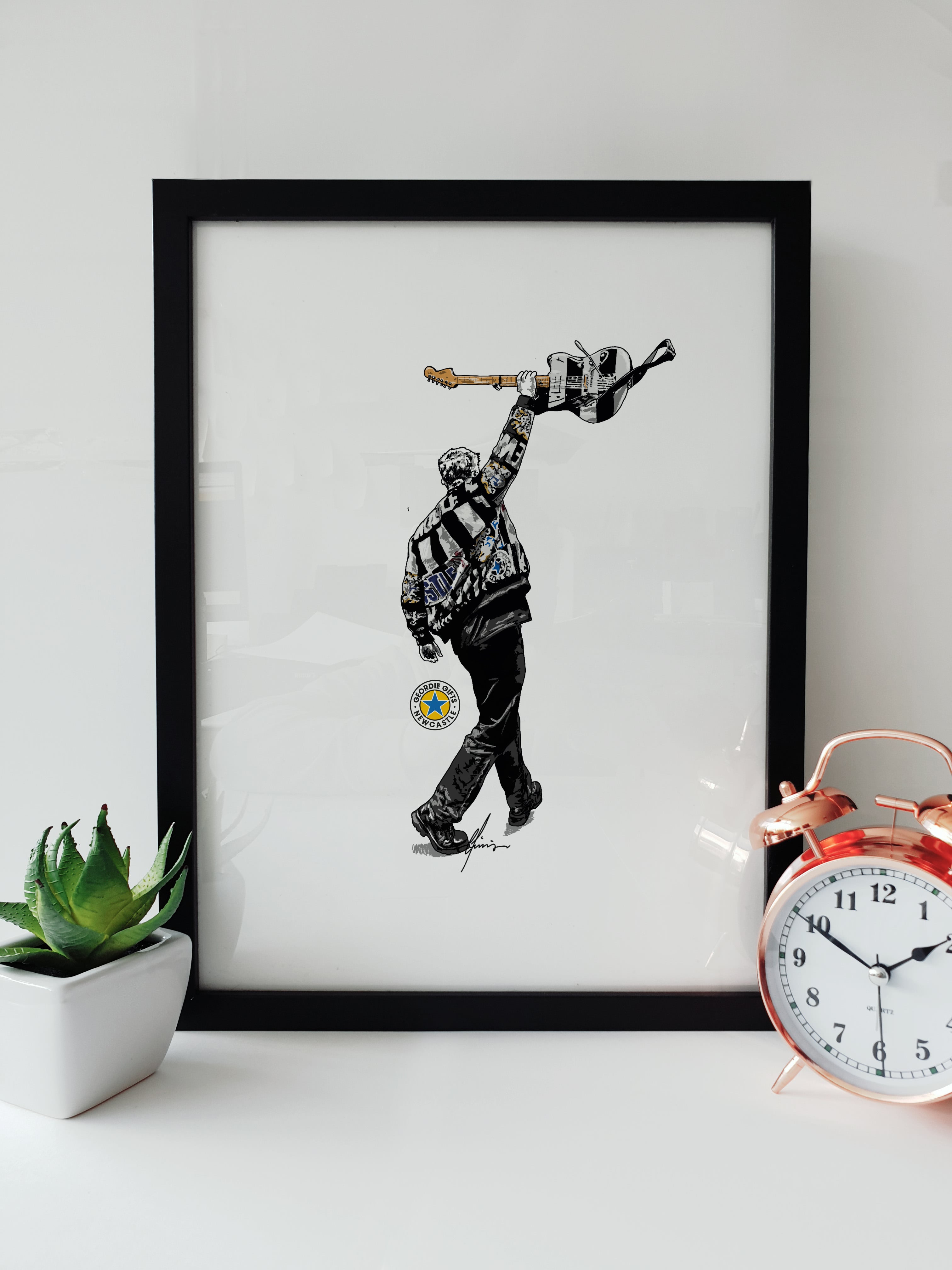 Geordie Gifts print of Sam Fender holding a guitar in Newcastle United colours at St James’ Park 2025 – black and white jacket illustration.