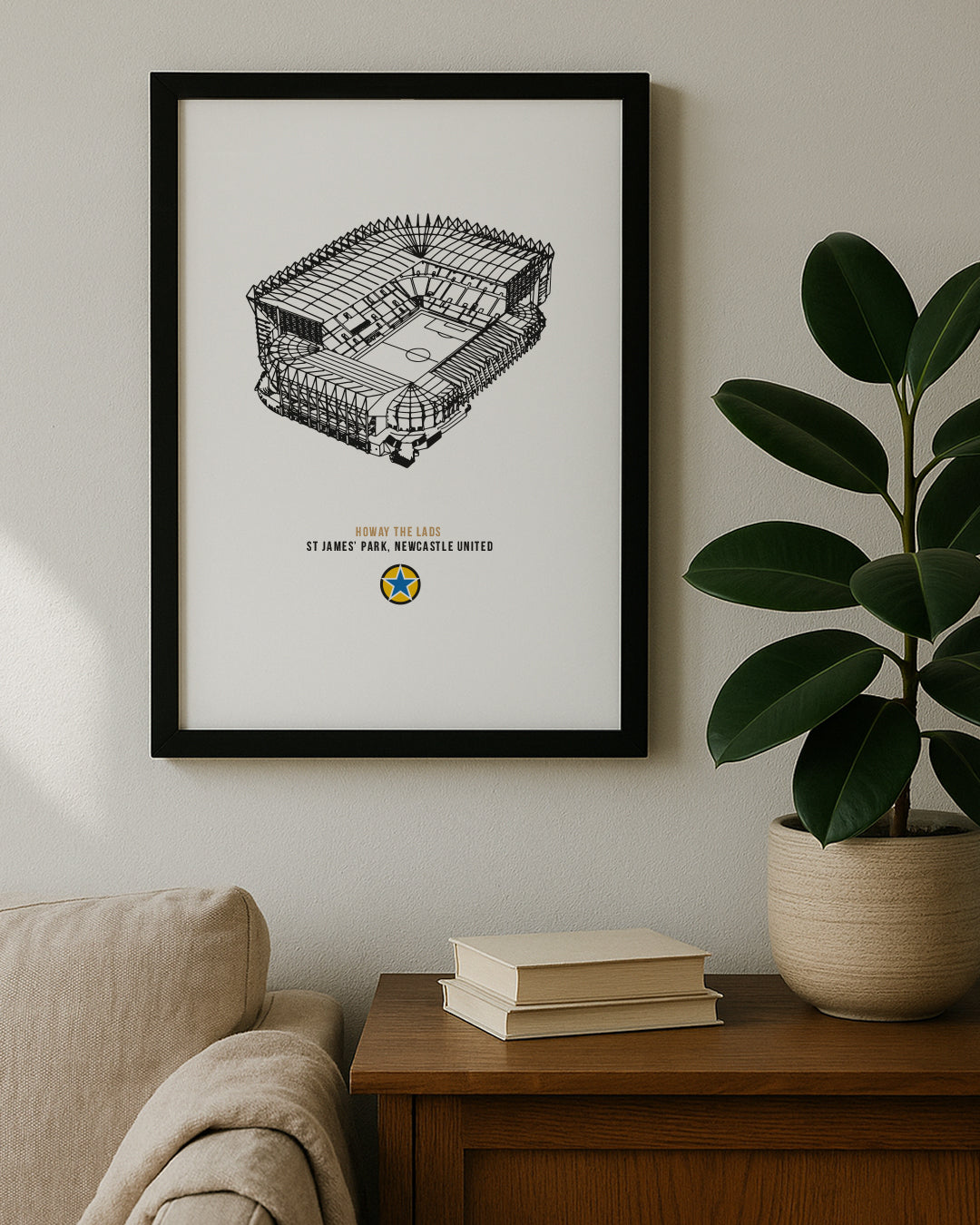The "Howay The Lads" St. James' Park stadium drawing hanging on a neutral wall next to a houseplant.
