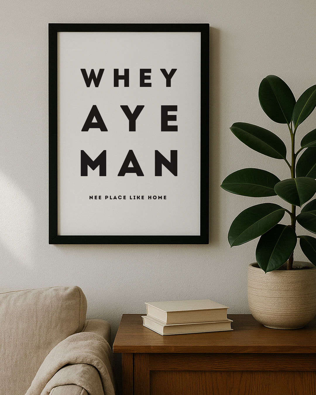 The "Whey Aye Man" Geordie Gifts wall art sitting on a wooden sideboard, featuring minimalist black and white Newcastle dialect design.