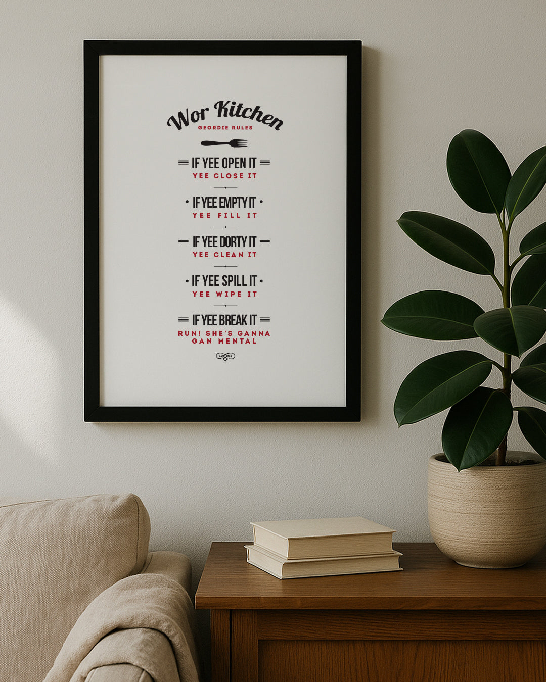 A black-framed 'Wor Kitchen' house rules poster sitting on a wooden sideboard.