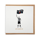 A Geordie Gifts Valentine's Day card featuring a black and white illustration of Bruno Guimarães holding a corner flag that reads "A Love Yee" with a red heart, shown against a kraft paper envelope.