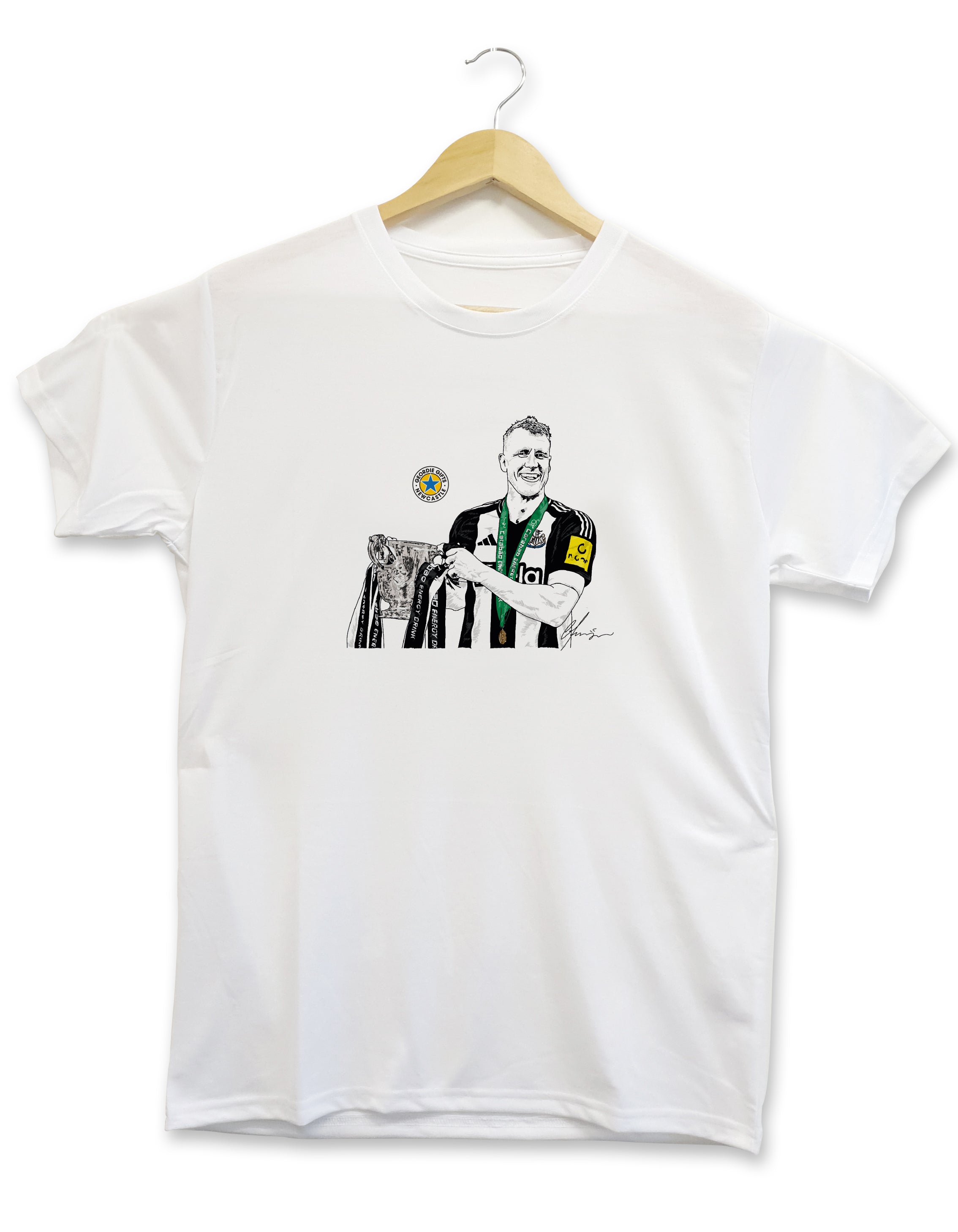 Geordie Gifts Newcastle United supporter T-shirt featuring a hand-drawn Dan Burn illustration holding the Carabao Cup trophy after the final at Wembley, displayed on a hanger.
