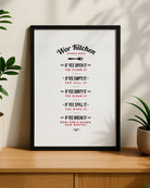 A framed Geordie Gifts 'Wor Kitchen' rules print hanging on a neutral wall next to a houseplant.