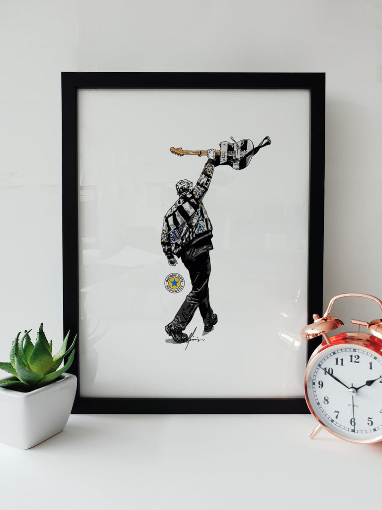 Geordie Gifts print of Sam Fender holding a guitar in Newcastle United colours at St James’ Park 2025 – black and white jacket illustration.