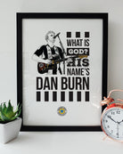 illustration of sam fender wearing a newcastle united shirt during his show in berlin on the night the toon army won the carabao cup final 2025 alongside the words what is god? his name's dan burn after he chanaged the lyrics to his song little bit closer. Print designed by geordie gifts
